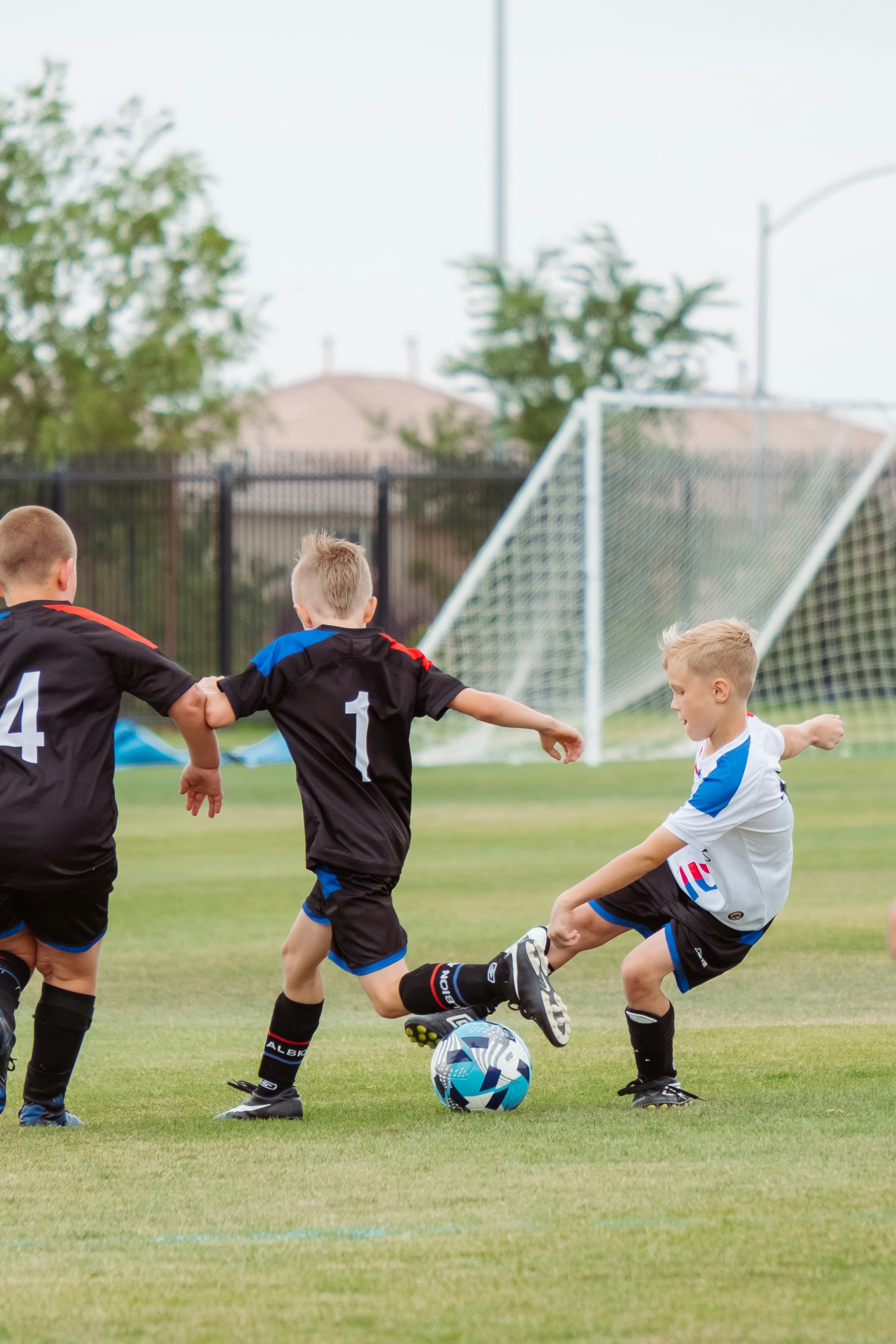 Two young footballers competing for the ball on grass at golden hour